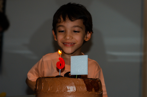 little boy on his birthday next to the cake and copy space