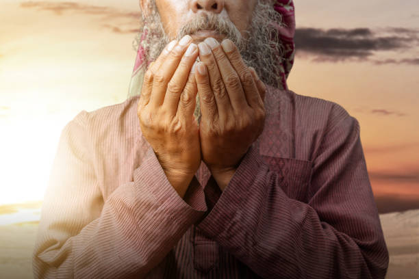 istock Muslim man with a beard wearing keffiyeh with agal in praying while raised hands 1510161655