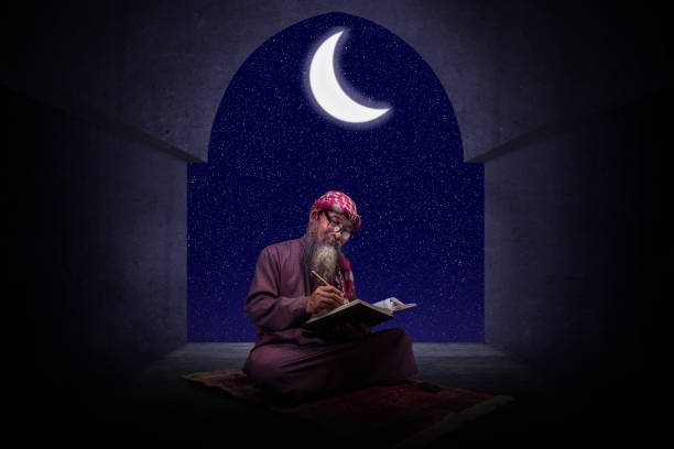 Muslim man with a beard wearing keffiyeh with agal sitting and reading the Quran on the prayer rug Muslim man with a beard wearing keffiyeh with agal sitting and reading the Quran on the prayer rug inside the mosque middle eastern ethnicity mature adult book reading stock pictures, royalty-free photos & images