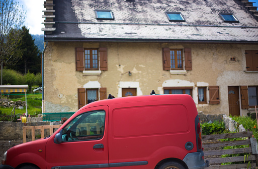 Méaudre, Le Vercors, France: A traditional rustic house with a stepped slate roof in the village of Méaudre, about 40 kilometers southwest of Grenoble; a red Renaud van is parked out front. The village is located in the Vercors Regional Natural Park.