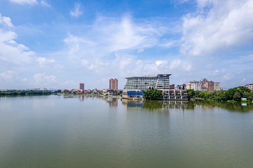 The lake reflects the city and the blue sky and white clouds