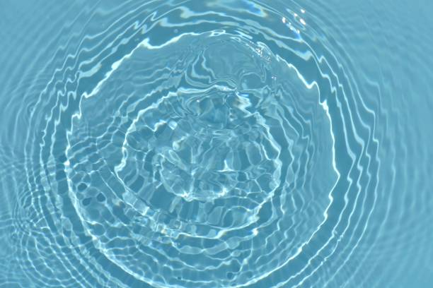 istock Blue water with ripples on the surface. Defocus blurred transparent blue colored clear calm water surface texture with splashes and bubbles. Water waves with shining pattern texture background. 1510282498