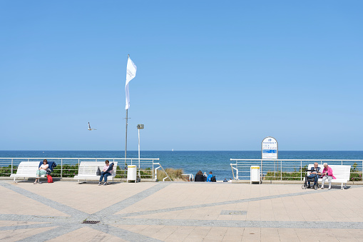 Kühlungsborn, Germany – May 27, 2023: popular beach promenade with benches and vacationers in baltic resort Kühlungsborn in summer in Germany