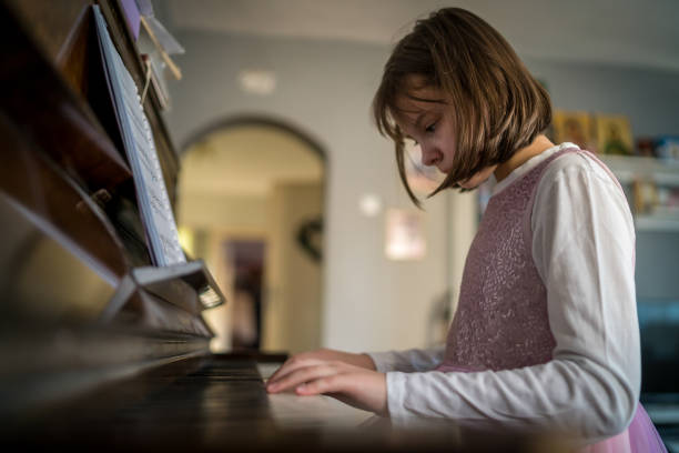 istock Cute girl playing piano at home 1510356026