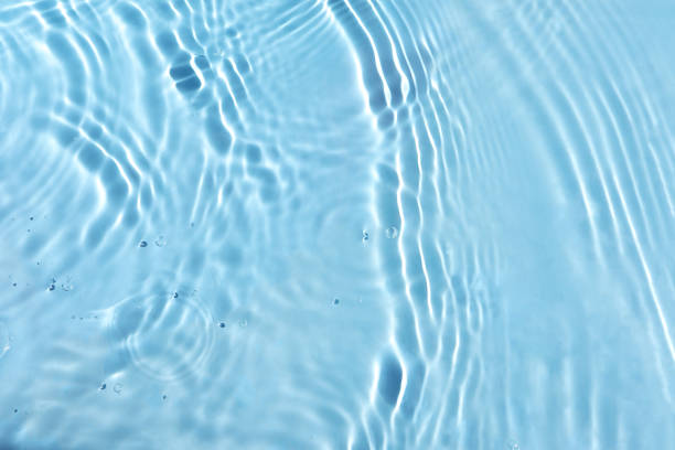 istock Texture of water surface reflections. Blurred transparent blue colored clear calm water surface texture with splash and bubbles. water waves with shining pattern texture background. 1510395238