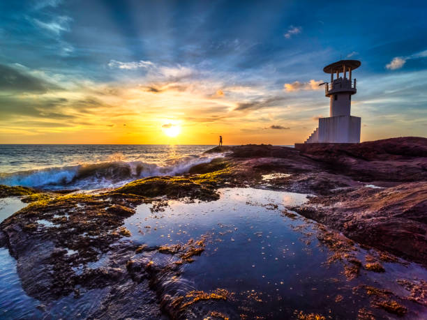 istock Oceanic Splendor: Lighthouse, Rugged Rocks, and the Glowing Evening Sun 1510397330