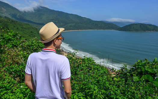 A young man looking at mountain scenery of Hai Van Pass in Da Nang, Vietnam.