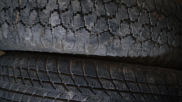 Two old car tires with different tire patterns. The difference between hard and road tires