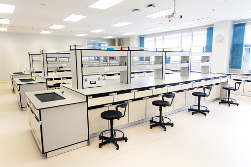New laboratory workbench with chairs furniture in science classroom interior of university college. Laboratory casework with shelf for experimental in laboratories room.