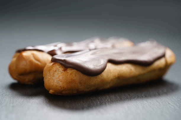 istock two eclairs with dark chocolate on top on slate background 1510480569
