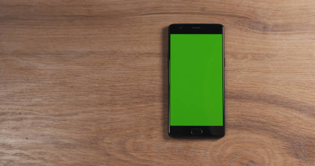 istock smartphone with green screen over wood table 1510518681