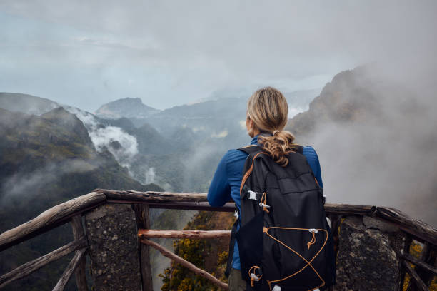 Cтоковое фото Вид сзади на женщину-туриста, смотрящую на горы.