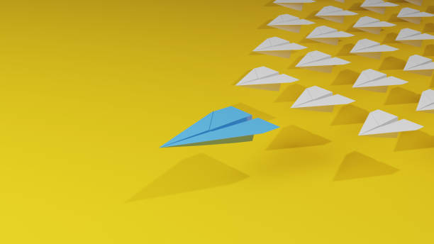 istock Leadership concept with blue paper plane leading among white on yellow background. 1510599414