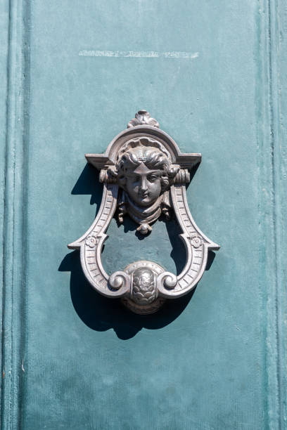 Antique Metal Knocker on green colored door on blurred background
