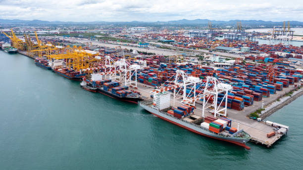 istock commercial port load and unloading cargo from container ship import and export by crane for distributing goods by trailers transported to customers and dealers, aerial view from drone 1510638842