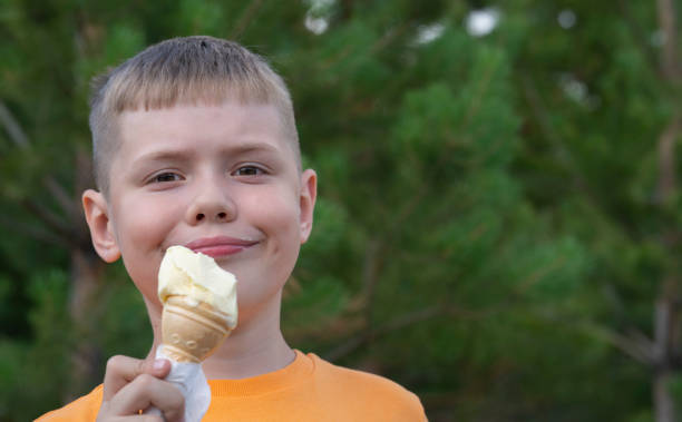 istock A blond boy of eight years old eats ice cream in a waffle cup. 1510661701