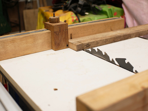 DIY cross cut sled on a table saw. A piece of wood will be cut.