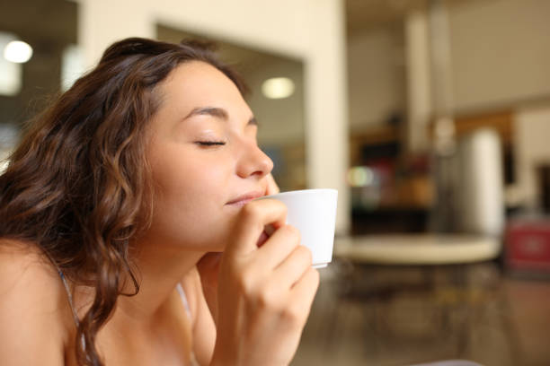 kobieta delektująca się aromatem kawy w restauracji - coffee time restaurant zdjęcia i obrazy z banku zdjęć