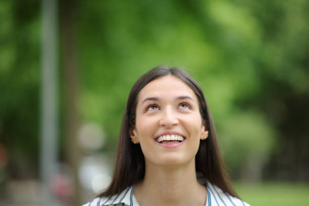 istock Happy woman looking abobe in a park 1510674036