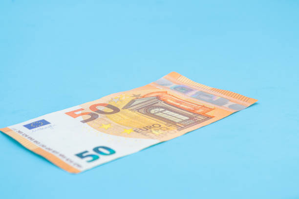 istock 50 euro bills on a blue background with copy space 1510681146