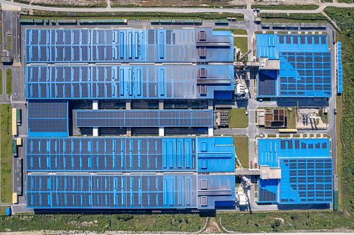 Vertical aerial view of a blue factory using solar panels
