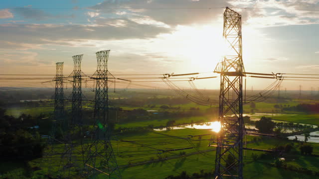 Dolly shot electricity pylons with sunrise