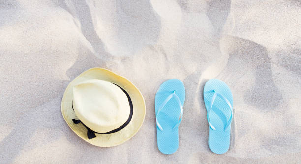 istock Summer accessories on beach texture banner background. Flip flops and hat on sand top view. Slippers shoes and vacation holiday concept. Copy space. Selective foucus 1510736214