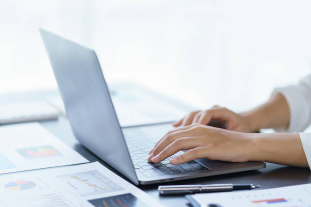 istock Close-up of a woman's hands sitting intently typing using laptop computer at the office fluently and several documents on the table. 1510747103
