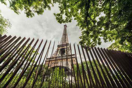 Low angle view of Tour Eiffel in May 2023. The Eiffel Tower (French: tour Eiffel) is a wrought-iron lattice tower on the Champ de Mars in Paris, France, and its tallest structure. It is named after the engineer Gustave Eiffel, whose company designed and built the tower. Locally nicknamed 