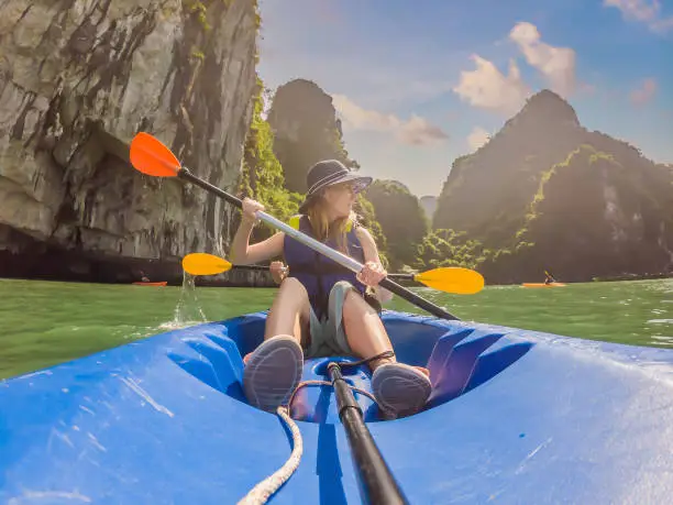 Mom, dad and son travelers rowing on a kayak in Halong Bay. Vietnam. Travel to Asia, happiness emotion, summer holiday concept. Traveling with children concept. After COVID 19. Picturesque sea landscape. Ha Long Bay, Vietnam.