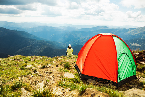 Woman with Tent on top of Mountain