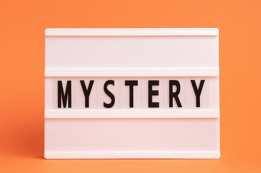 The word mystery on lightbox isolated orange background. Literary Genres