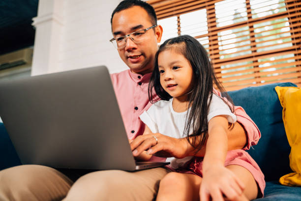 istock Father using laptop playing with daughter in living room 1510826739