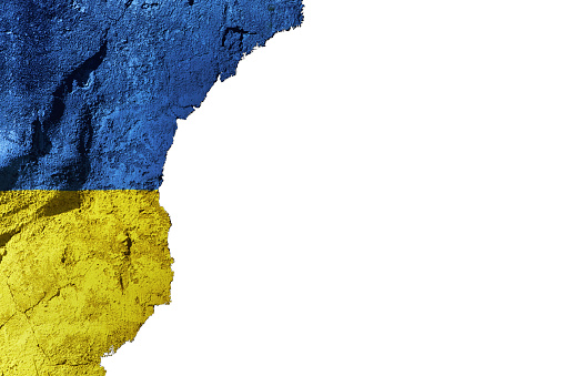 Ukrainian flag on cracked, roughly plastered wall with white copyspace.