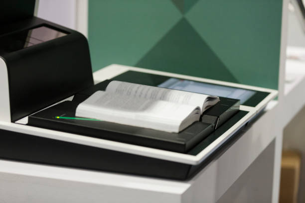 Laser beam over open book on photocopier, programed automated machine
