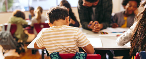 istock Rearview of a small boy doing his work in a primary school class 1510863789