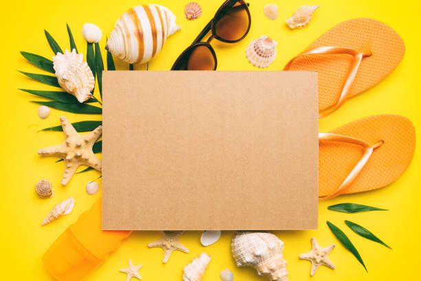 istock Summer time concept with blank greeting card and blank craft paper on colored background. Seashells from ocean shore in the shape of frame separated with space for text top view 1510864332