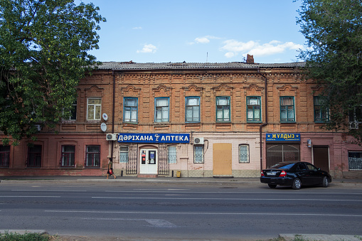 Uralsk, Kazakhstan (Qazaqstan), 13.08.2020 - pharmacy located in the old building. Blue signboard pharmacy in Kazakhstan
