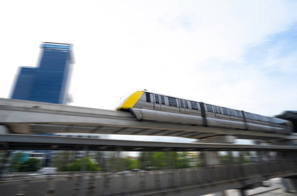 Elevated monorail train fast move on rail. Public transit monorail. Modern mass transit. Rail transportation. Driverless straddle monorail. Monorail technology. Rapid transit in city. Urban transport. el tren elevado del monorraíl se mueve rápidamente sobre el riel. monorriel de transporte público. transporte público moderno. transporte ferroviario. monorraíl a horcajadas sin conductor. tecnología de monorraíl. tránsito rápido en ciudad. transp