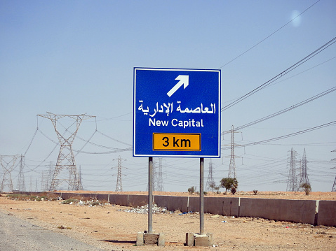 Traffic road Signboard on Suez Cairo Highway gives the direction of New Administrative Capital (NAC) Translated in Arabic and English languages, a new urban community in Cairo Governorate, Egypt, selective focus