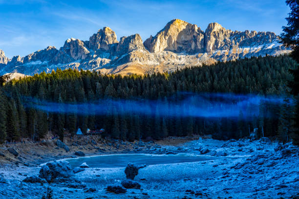 apertura del lago karersee in inverno - latemar mountain range foto e immagini stock