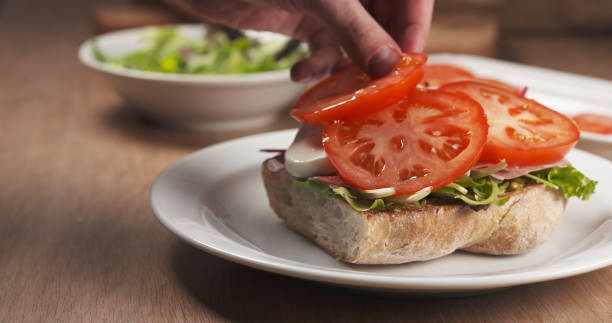 istock shot of tomato put on ciabatta bread preparing sandwich 1510940311