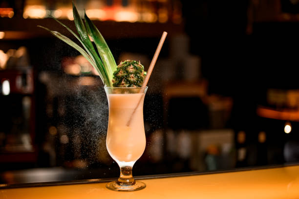 bicchiere da cocktail cristallino con deliziosa bevanda alcolica pina colada sul bancone del bar - cocktail pina colada pineapple juice foto e immagini stock