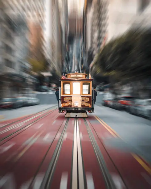 An iconic tram driving along California Street with a motion blur effect
