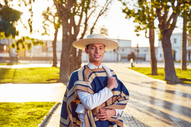 waist up portrait latin american young adult wearing chilean huaso costume on the street. stock photo