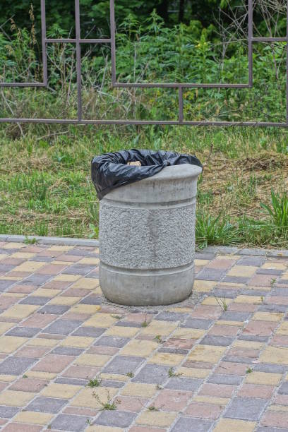 istock one gray concrete urn with a black bag stands on a brown sidewalk 1511007072