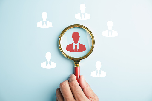 HRM vision Magnifier glass zooms in on manager icon, symbolizing the strategic role of human resource management in human development, recruitment, and leadership. employees selection