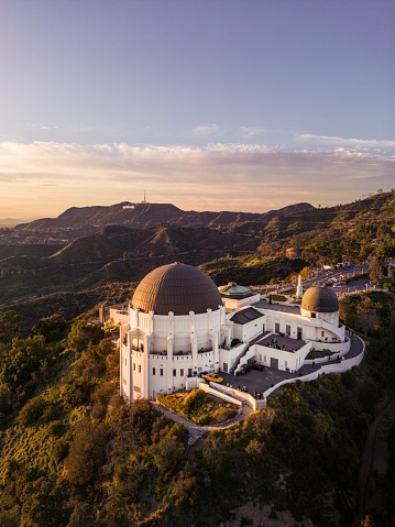 A majestic view of the Griffith Observatory nestled atop a mountain at the golden hour of sunset