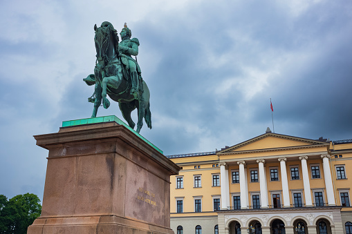 Oslo, Norway, June 20, 2023: Tourists visit the Royal Palace during a stormy day. It is where the monarchy works, the King presides over the Council of State and where the King and Queen live.