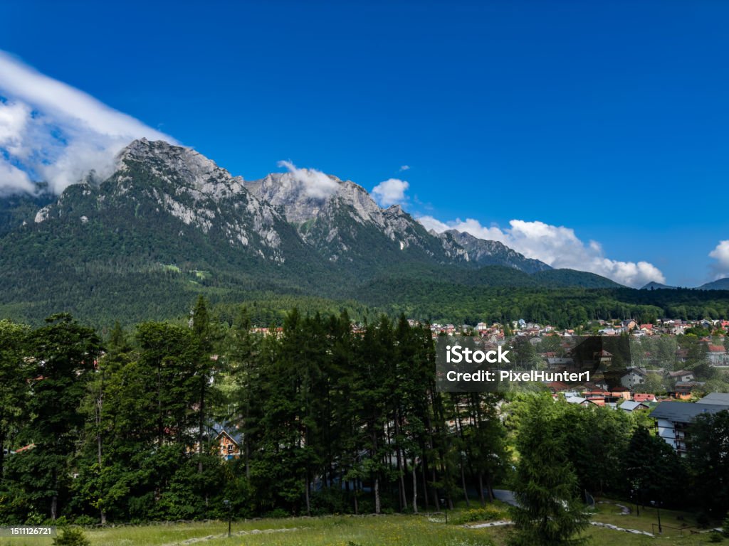 Mountains- Busteni , Romania Nature's masterpiece unfolds before you, with jagged peaks standing tall against a backdrop of clear blue skies. Blue Stock Photo